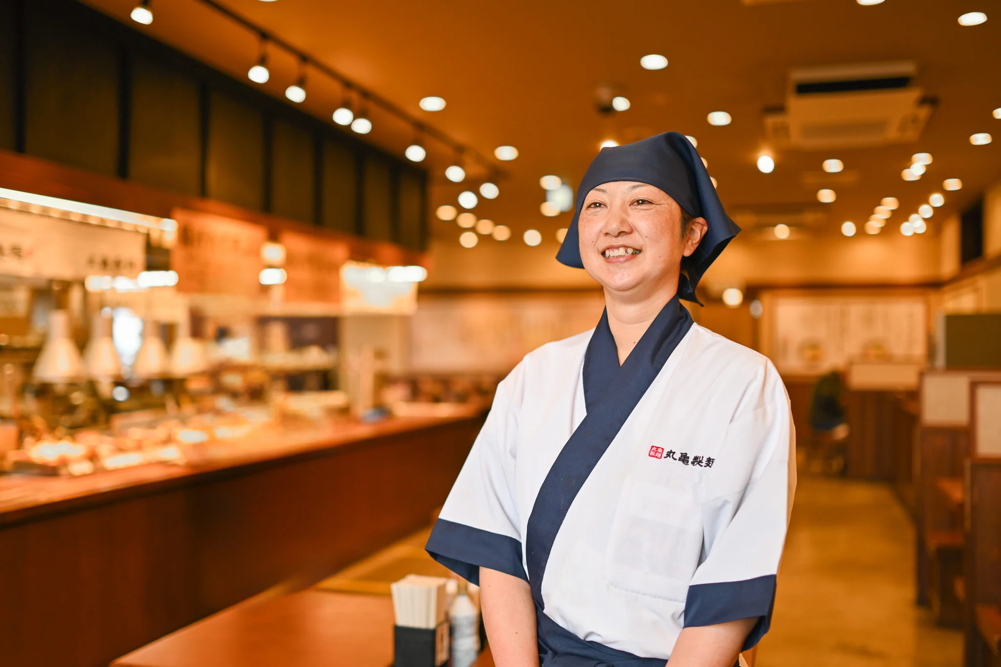 麺職人の制服を着用した丸亀製麺スタッフ