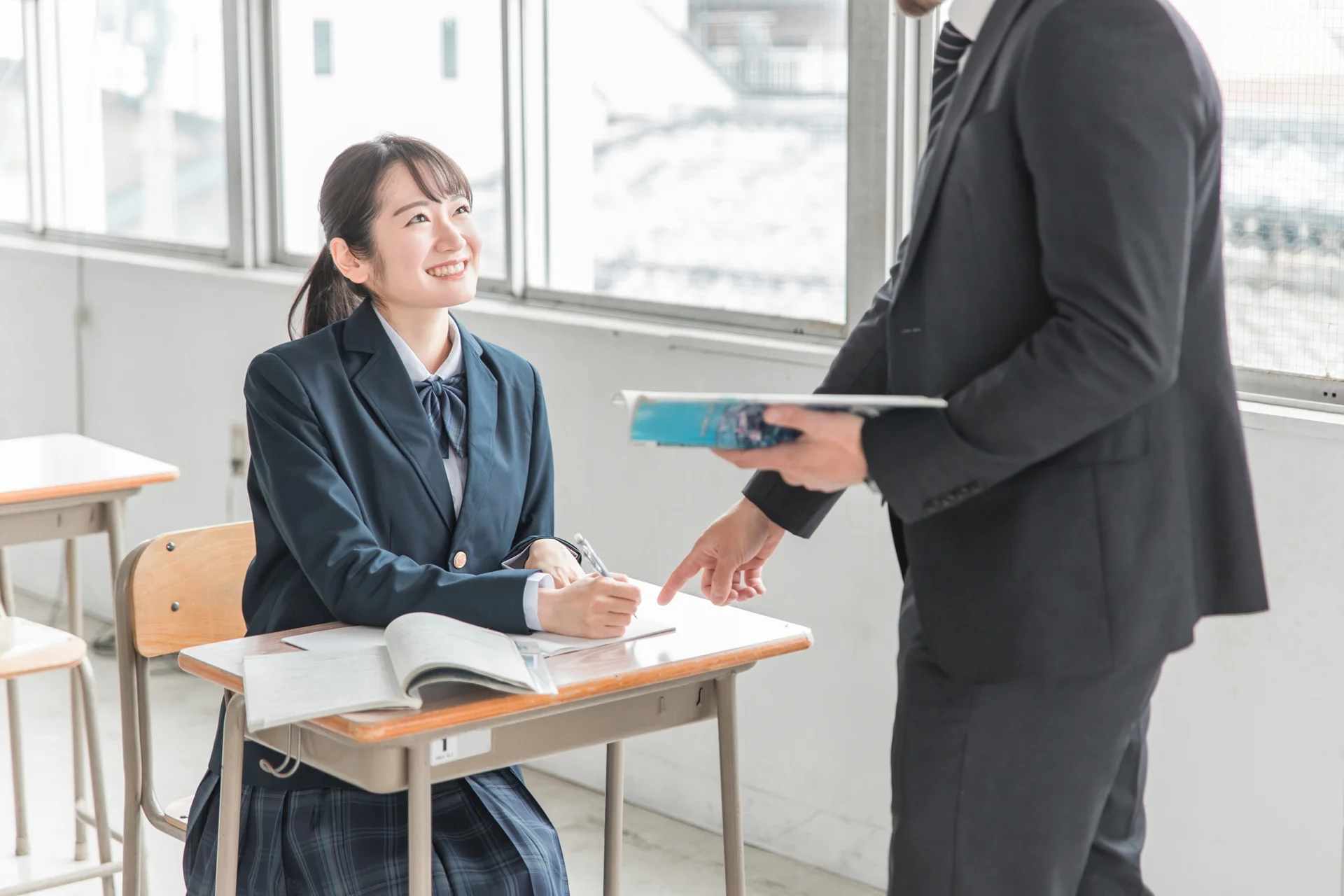 学校の先生にアルバイトについて相談する学生のイメージ