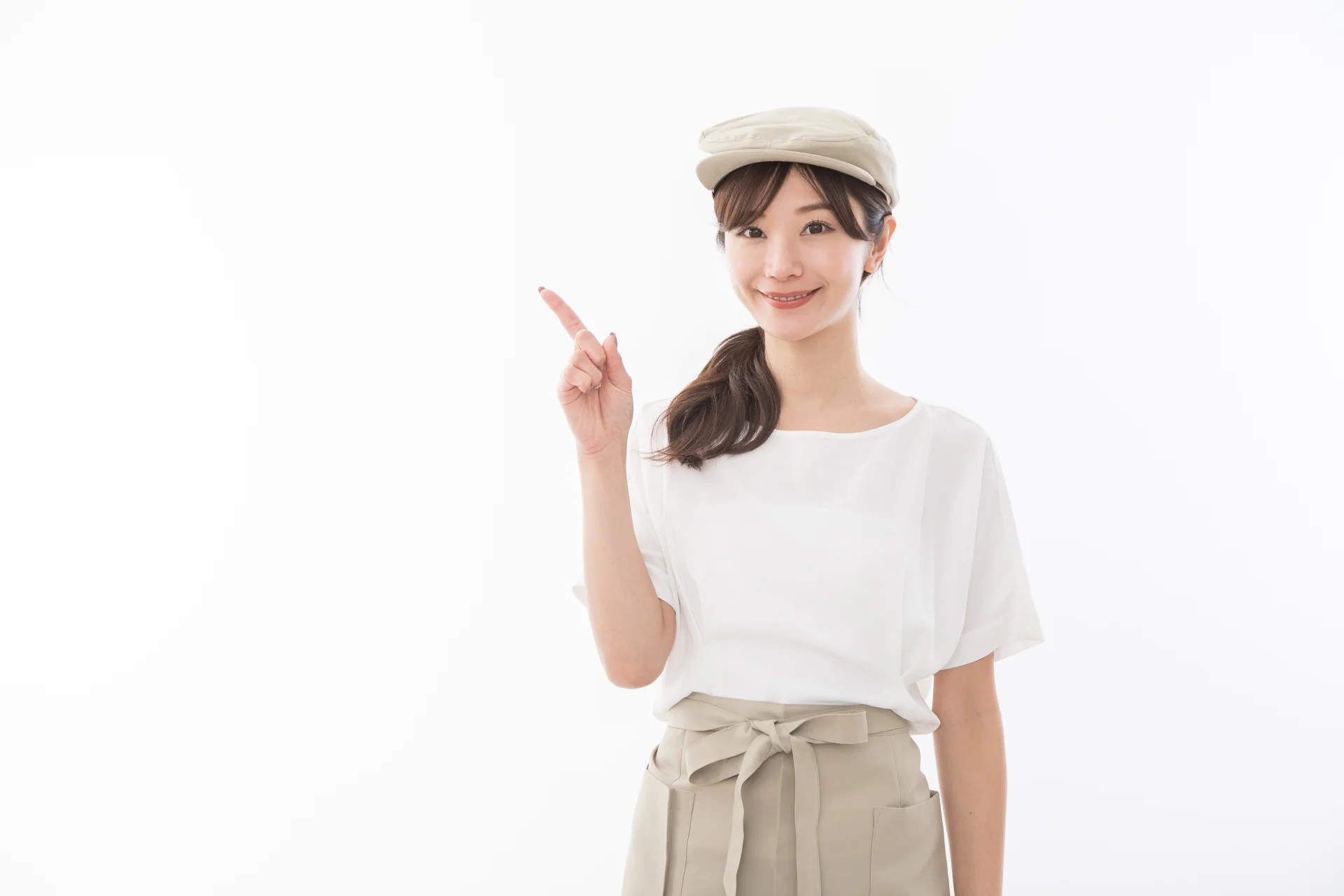 飲食の格好をしている女性が指差をしている様子