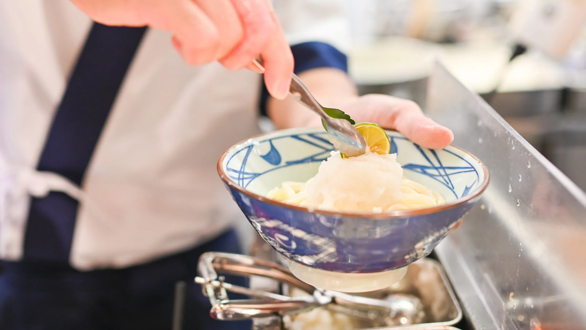 うどんを盛り付けるスタッフ