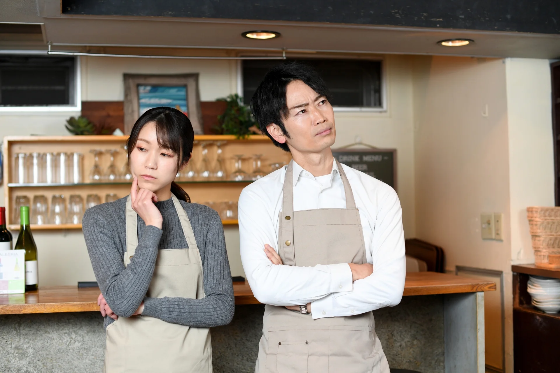 腕組みをしており、悩んでいる男女