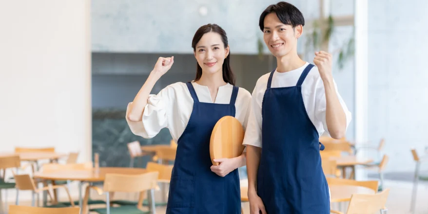 ガッツポーズをしている飲食店スタッフの男女